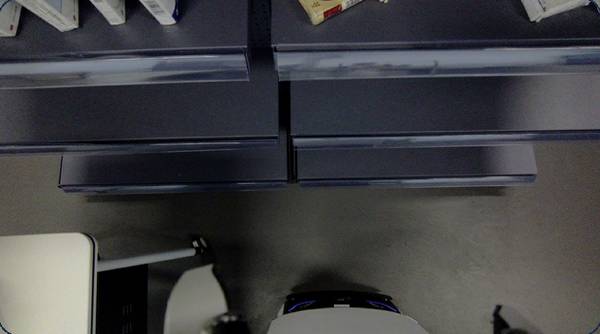 Wheeled robot at a pharmacy-style shelf